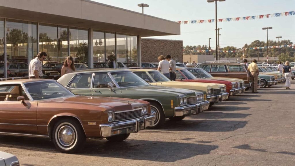 American car dealership filled with new cars in the 1970s