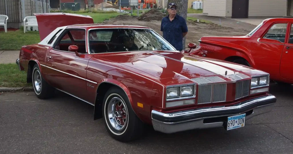 a red Oldsmobile Cutlass Supreme of 1976